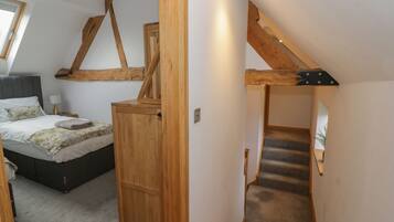 Une chambre à coucher avec un lit, une armoire en bois et un escalier.