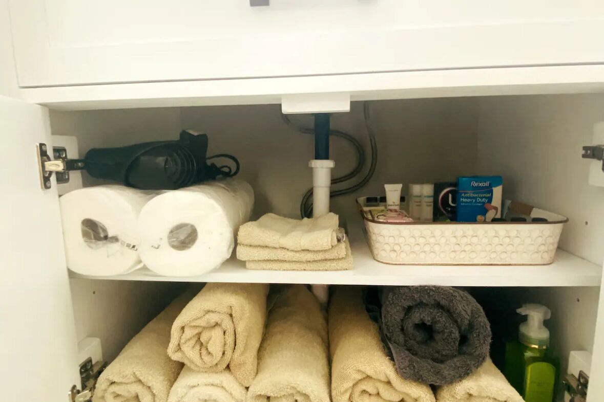 Kylpyhuoneen kaapissa on wc-paperia, pyyhkeitä, hiustenkuivaaja ja muita hygieniatarvikkeita.