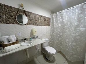 A bathroom with a white sink, a toilet, and a shower curtain with a sea-themed pattern. - Sam Day Suítes (Natal)