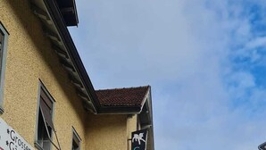 A street view with a building featuring a sign for 'Gästehaus' and a parked car. - Guest House Hotel (Arbon)