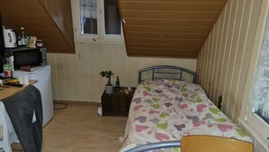 A small, cozy room with a bed, a desk, and a window. - Guest House Hotel (Arbon)