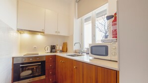 Eine kleine Küche mit eingebautem Backofen, einer Mikrowelle und einem Spülbecken.