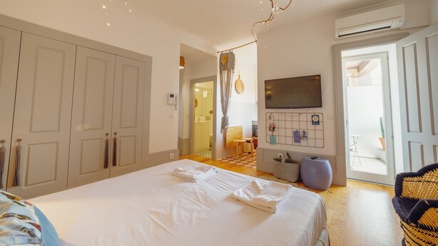 Ein Schlafzimmer mit einem großen Bett, einem Kleiderschrank und einem Fernseher an der Wand.