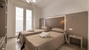 Une chambre d’hôtel moderne avec deux lits, une grande fenêtre et un design minimaliste.