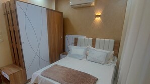 Un dormitorio moderno con una cama grande, un armario y un equipo de aire acondicionado en la pared.