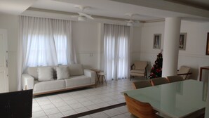 Ein Wohnzimmer mit einer Couch, einem Esstisch mit Stühlen, einem kleinen runden Tisch und einem Weihnachtsbaum.
