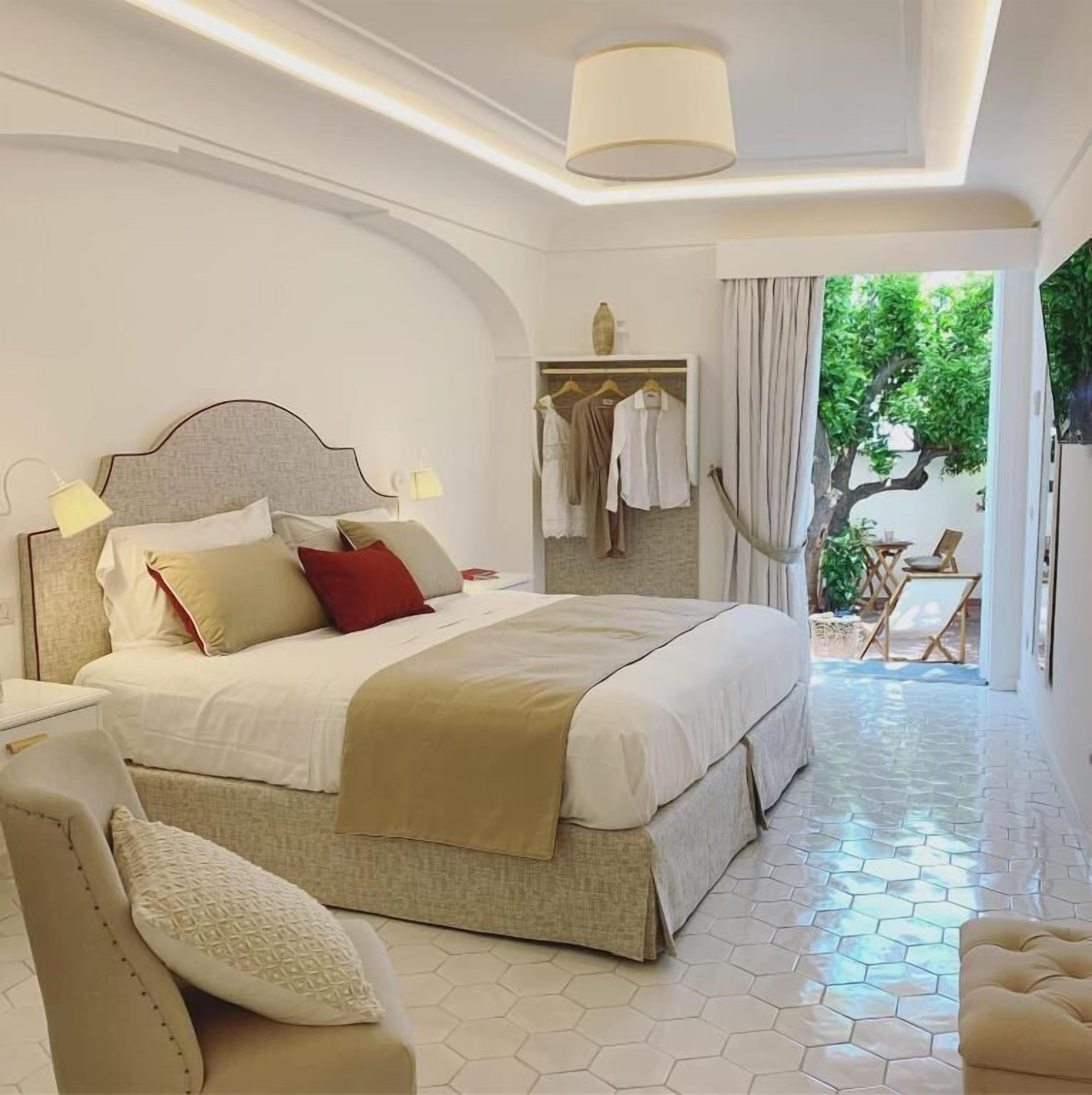 Un dormitorio con una cama grande, lámparas de noche, un armario y vistas al exterior.