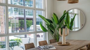 A wooden dining table with a potted plant and a mirror. - Casa Ocean Queen Bed Front Room (Miami Beach)