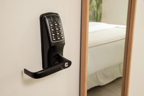 A door with a black electronic keypad lock.