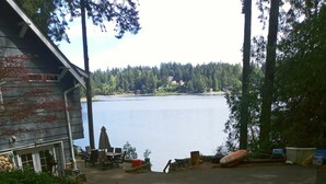 A lakeside view with a building, outdoor seating, and a dock. - Bremerton Sheltered Waterfront (Bremerton)