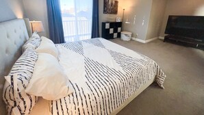 A hotel room with a large bed, a ceiling fan, a television, and a window with curtains. - Peaceful 3bed3bath 2300sqft Home Centrally Located in Heart of Silicon Valley (Santa Clara)