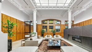 A spacious living room with a fireplace, comfortable seating, and large windows. - Stunning City Views 2B2B apt in CBD (Melbourne)