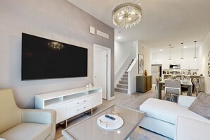 Relax in this stylish living room with a flat-screen TV, entertainment unit, and comfortable seating area.