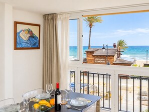 Una habitación con una mesa dispuesta para comer, una botella de vino y vistas a la playa y al océano.