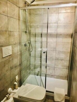 Deluxe kamer | Badkamer | Een douche, designer toiletartikelen, een haardroger, handdoeken