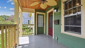 A porch with a ceiling fan, a red door, and a view of a neighboring house. - TigerTown Retreat. Downtown Baton Rouge and 5 minutes to LSU. (Baton Rouge)