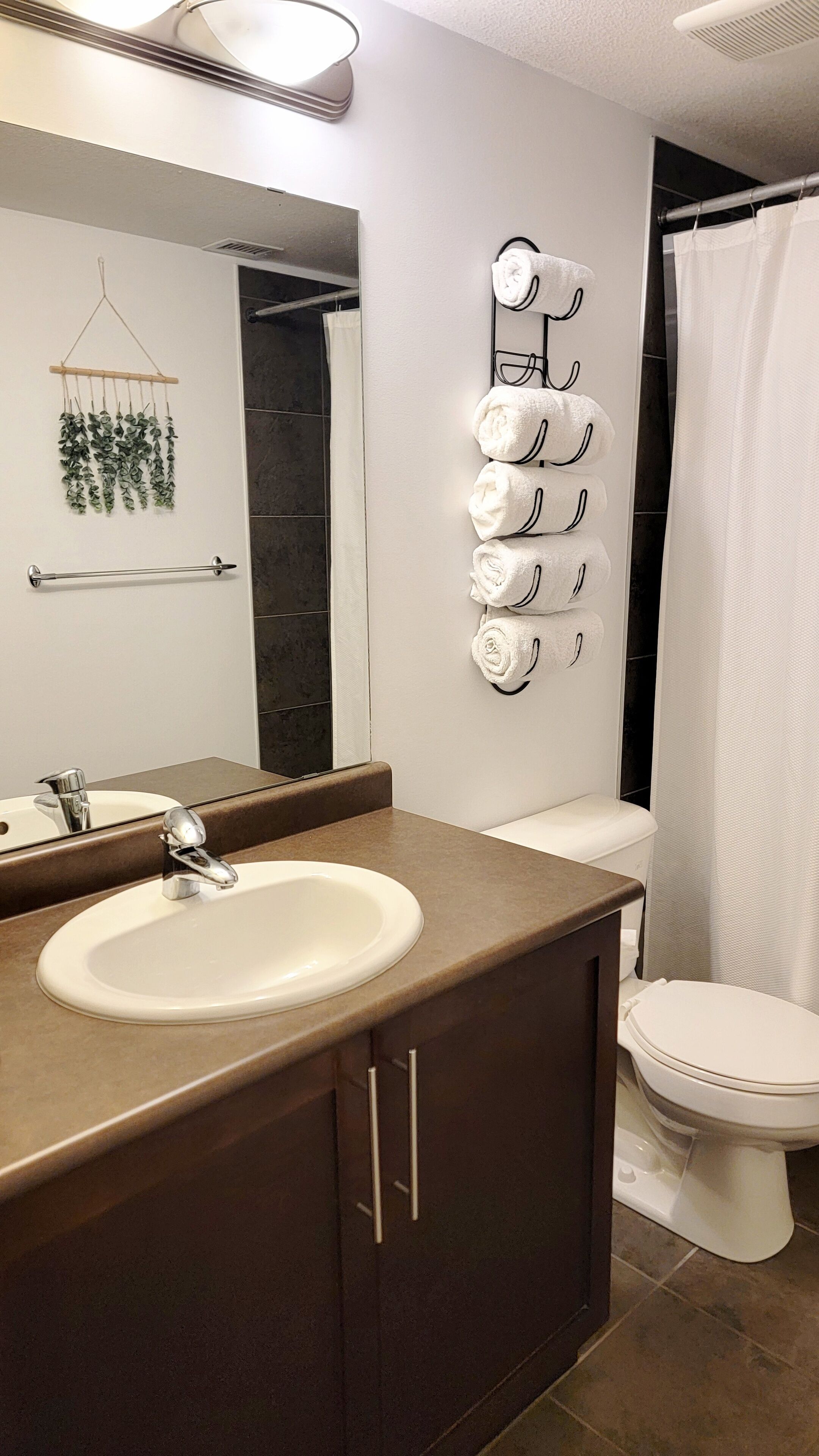 Une salle de bain équipée d’un lavabo, d’un miroir, d’un porte-serviettes et de toilettes.