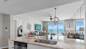 A modern kitchen with a large island, a dishwasher, and a view of the balcony. - Majestic Sun A404*Remodeled*Gulf Views*HeatedPools*Hot Tubs*Beach Gears (Miramar Beach)