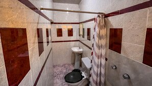 Une petite salle de bain avec des toilettes, un lavabo et une douche.