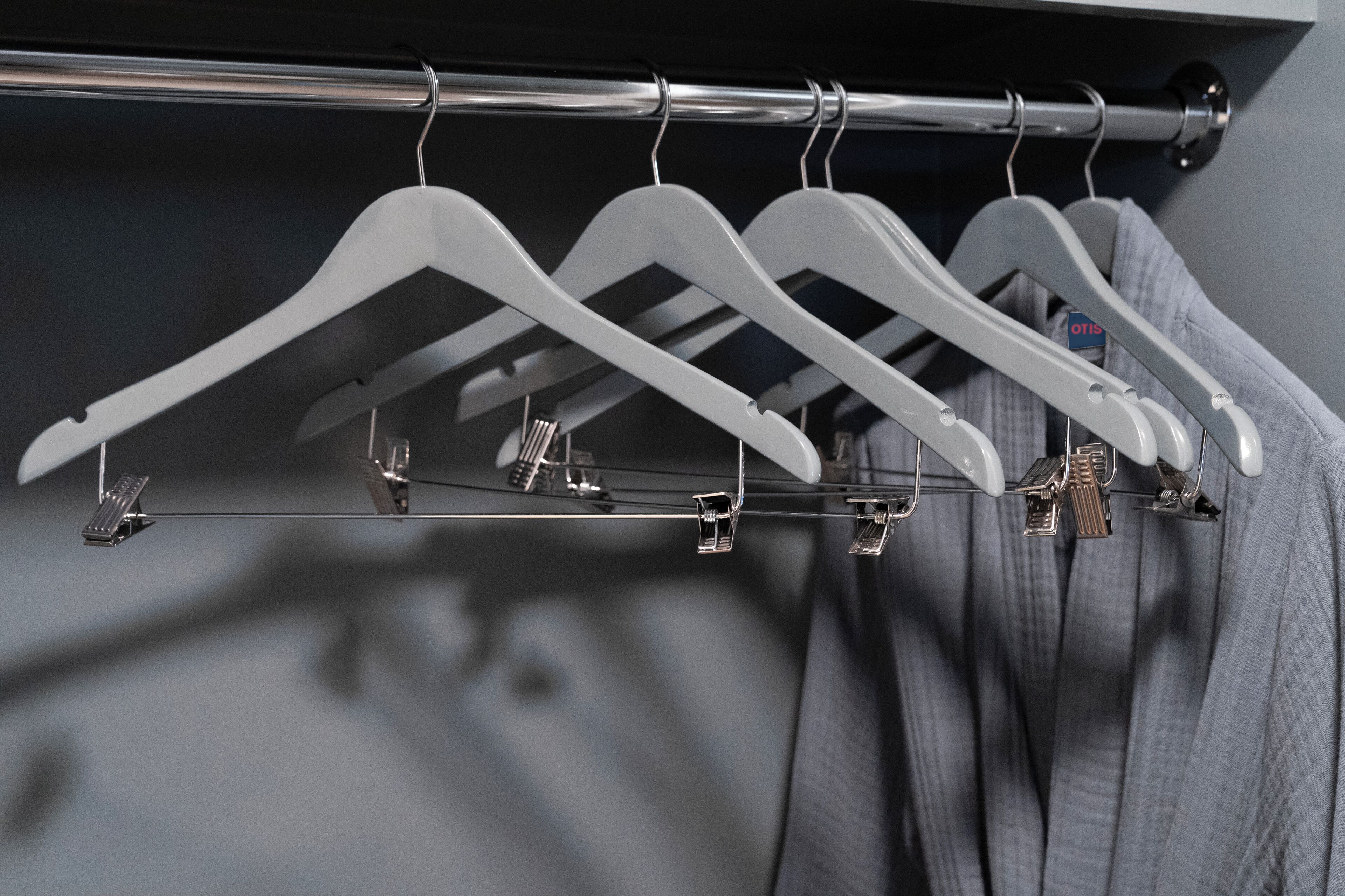 A closet with white hangers and a metal rod.