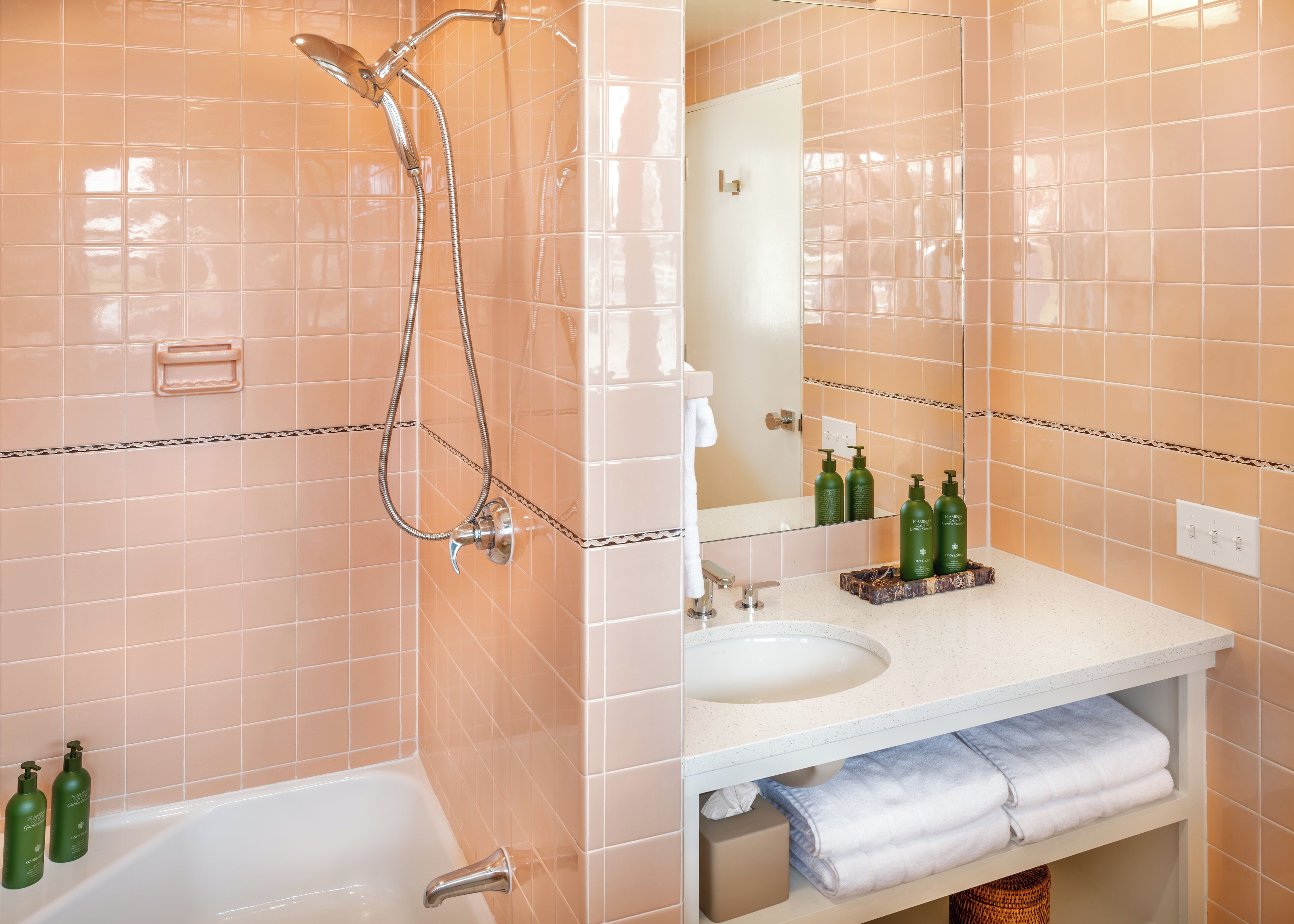 Ein Badezimmer mit einer Badewanne, einer Dusche, einem Waschbecken und einem Spiegel.