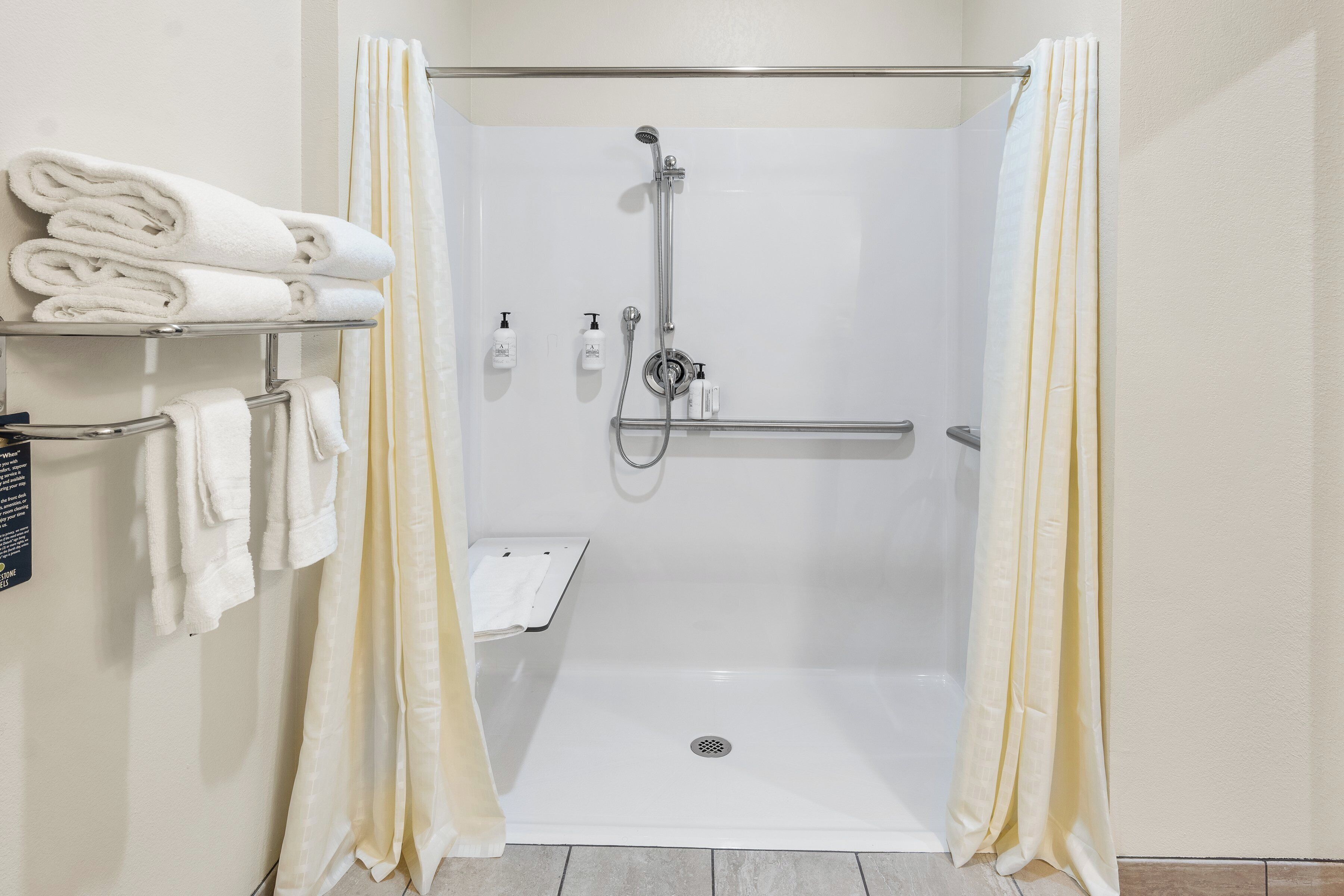 A shower area with a white bathtub, a hand shower, and a glass-enclosed shower stall.