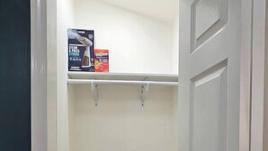 A closet with two shelves, a door, and a wooden floor. - Cozy 1-bdrm/1 bath, desk, grill, deck, laundry (Phenix City)