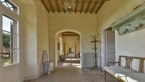 Un hall d’entrée spacieux, doté d’un sol en pierre, d’un banc et d’un radiateur.