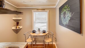A compact kitchen with a dining table, chairs, and a window with blinds. - Quiet Country Studio Between Saugatuck & Holland! (Holland)