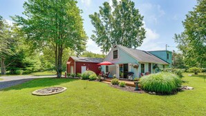 A two-story house with a red garage, a blue house, and a well-maintained lawn. - Quiet Country Studio Between Saugatuck & Holland! (Holland)