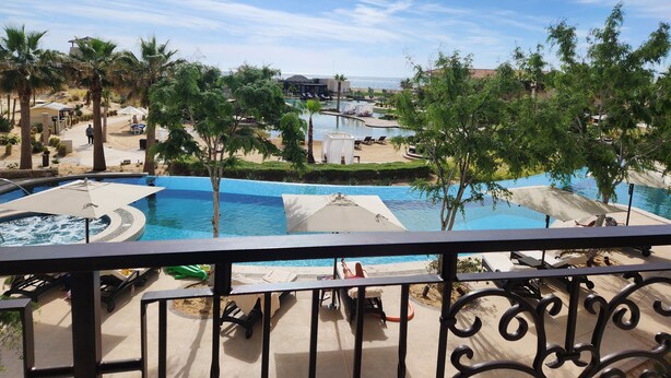 A resort pool area with multiple pools, lounge chairs, and palm trees. - Welcome to Your Dream Getaway at Grand Solmar Pacific Dunes, Cabo! (Cabo San Lucas)