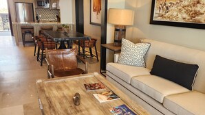 A spacious living area with a wooden coffee table, leather chairs, a sofa with patterned cushions, and a dining area with a large table and chairs. - Welcome to Your Dream Getaway at Grand Solmar Pacific Dunes, Cabo! (Cabo San Lucas)