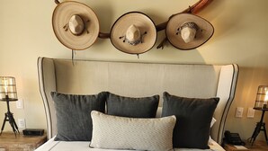 A bed with a white bedspread, three dark pillows, and three sombreros on the headboard. - Welcome to Your Dream Getaway at Grand Solmar Pacific Dunes, Cabo! (Cabo San Lucas)