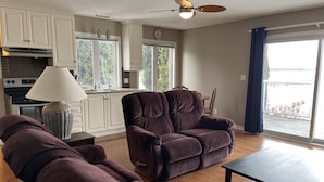 A living room with a sofa, a table, and a view of the outside.