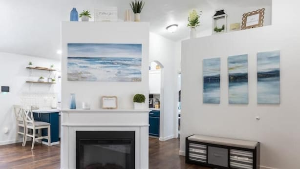 A modern living room with a fireplace, a dining area with a white table and chairs, and a kitchen in the background. - Beautiful Home in Central Nampa (Nampa)