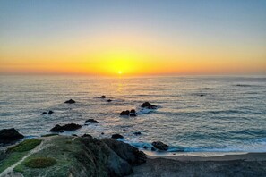 A coastal sunset with rocky terrain and calm sea. - Hansen's Bodega Bay Getaway-Walk to Beach! (Bodega Bay)