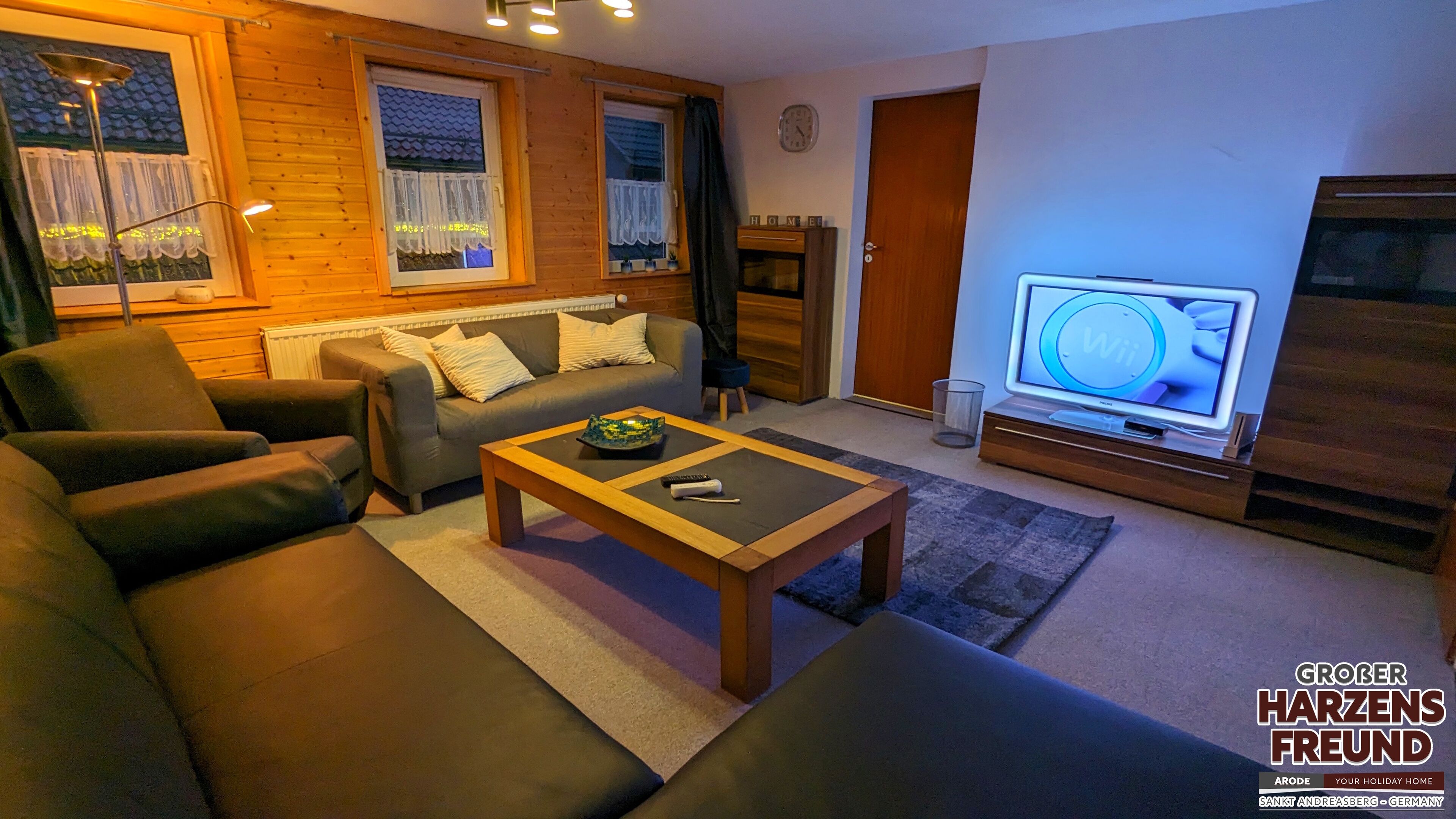 Ein gemütliches Wohnzimmer mit einer Couch, einem Couchtisch und einem Fernseher.