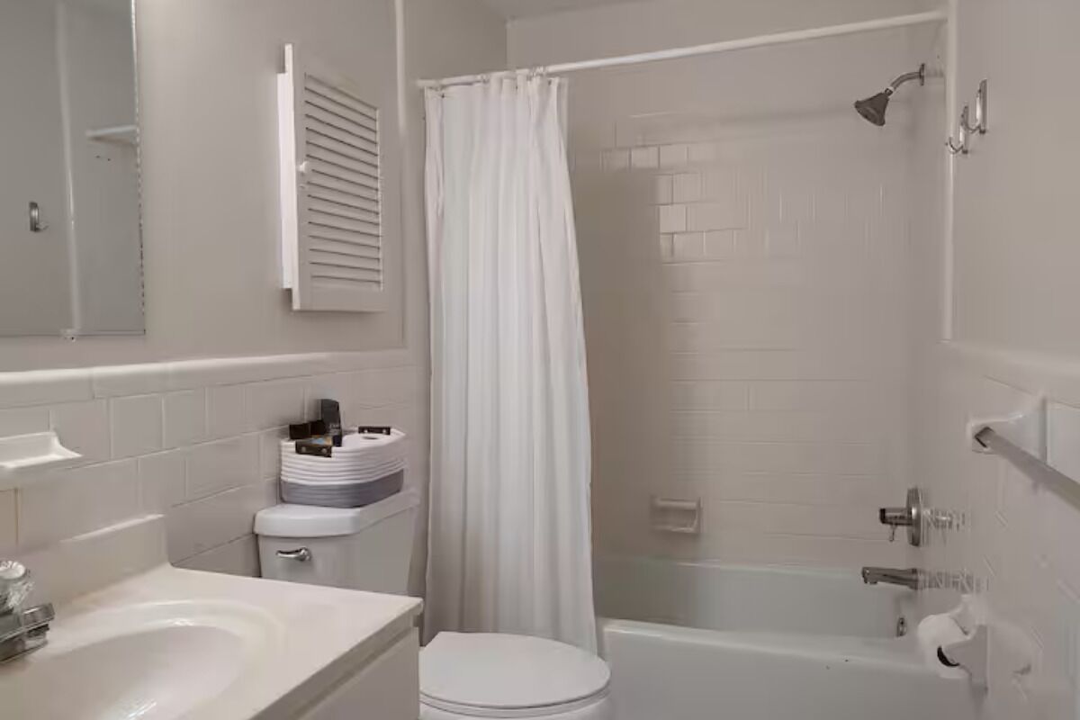 A bathroom with a bathtub, toilet, and sink.