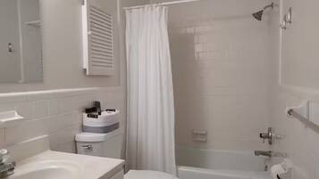 A bathroom with a bathtub, toilet, and sink.