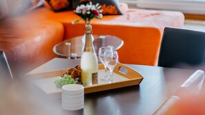 A dining table with a bottle of champagne, a glass, and a tray with food and a cup. - Apartment Jagoda near the beach (Okrug Gornji)