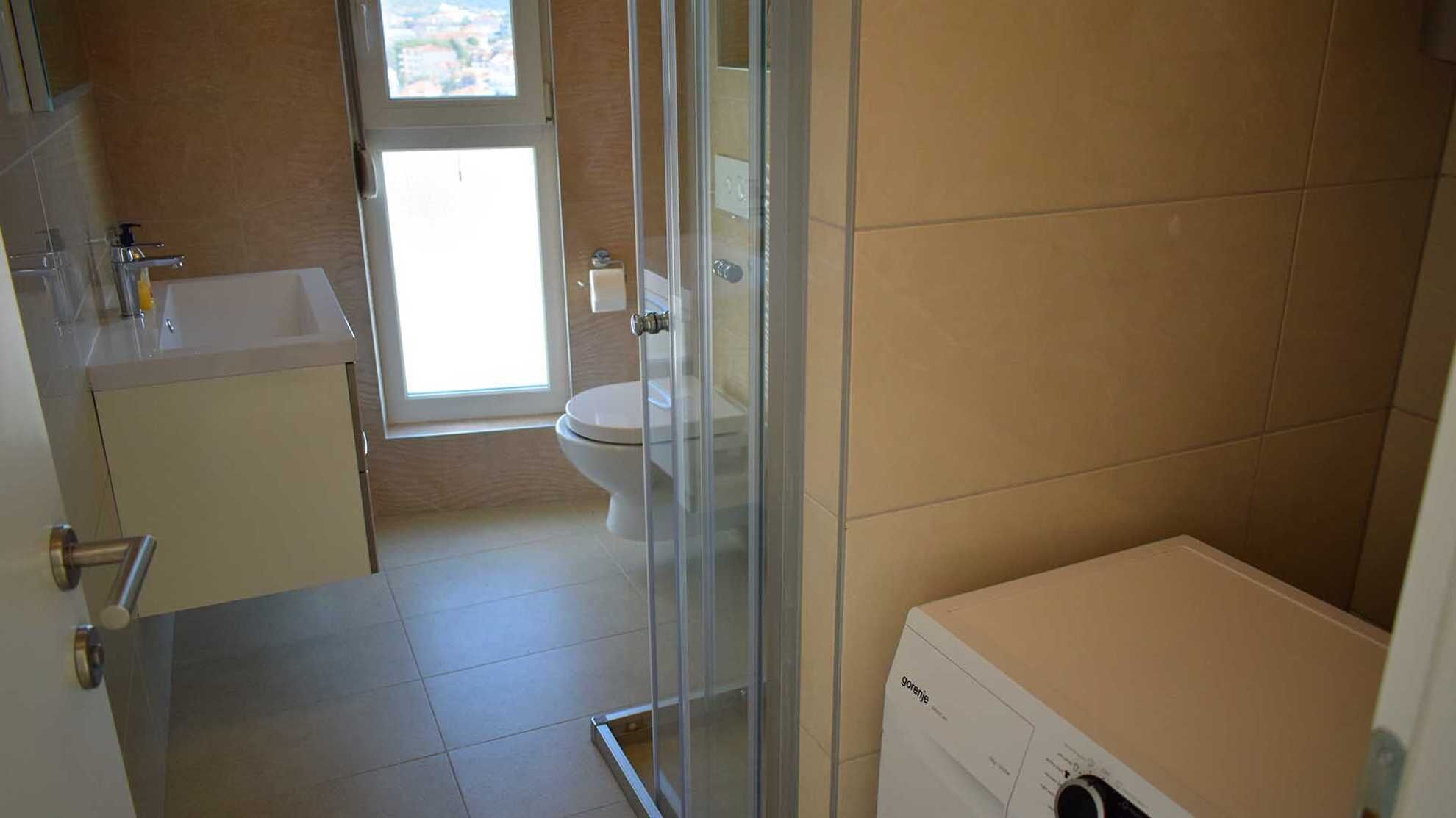 A bathroom with a toilet, a sink, and a glass shower enclosure.