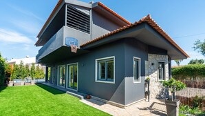 Une maison moderne à deux étages, dotée d’un toit en pente, de grandes fenêtres et d’une pelouse bien entretenue.