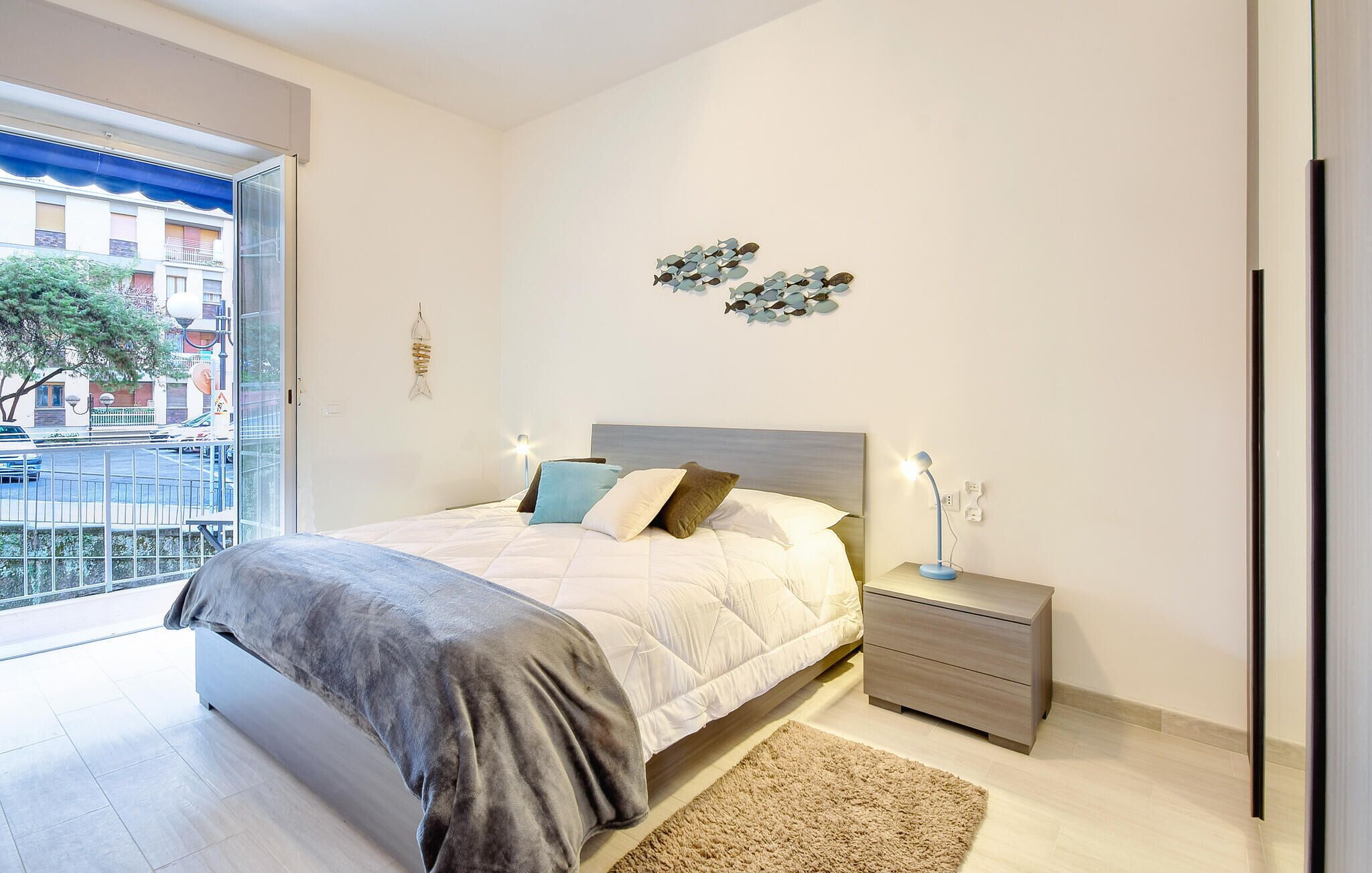 Ein Schlafzimmer mit Bett, Nachttisch und Blick ins Freie.