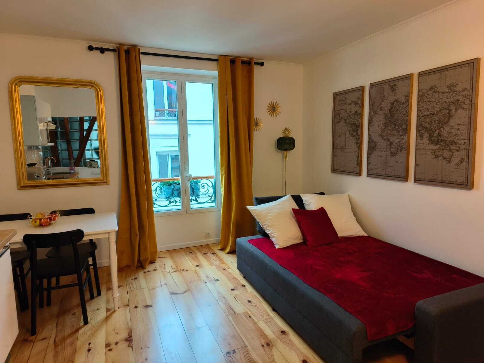 Ein Zimmer mit Bett, Schreibtisch, Stuhl, einem Fenster mit Vorhängen und Wanddekoration.