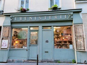 Une boutique dont l’enseigne, « EBENISTERIE », est placée au-dessus de l’entrée.