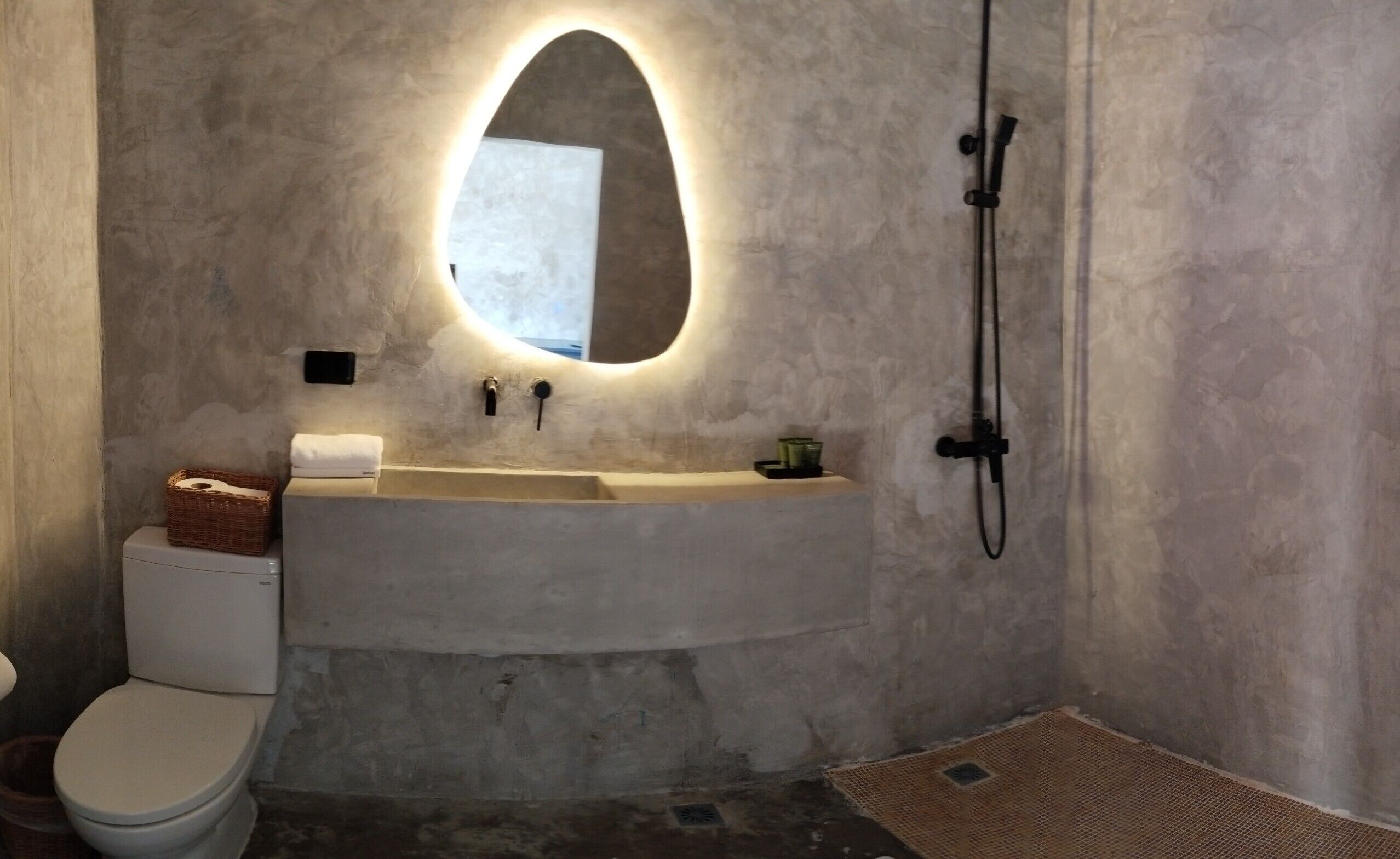 Ein Badezimmer mit Toilette, Waschbecken mit Spiegel und Dusche.