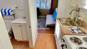 A compact kitchen with a stove, sink, and a small dining area.