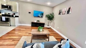 A modern living room with a sofa, coffee table, and a TV mounted on the wall. - 402 Stylish luxe Apt at center city self check-in (Philadelphia)