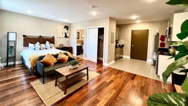 A spacious room with a large bed, a coffee table, and a kitchen area. - 402 Stylish luxe Apt at center city self check-in (Philadelphia)