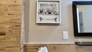 A bathroom with wooden paneling, a framed quote on the wall, a small orchid plant, and a mirror. - 405 Spacious and superior 1BDR APT in center city (Philadelphia)